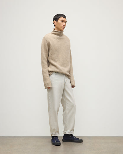 MALE MODEL WEARING JOHNSTOS OF ELGIN KESTER FUNNEL NECK SWEATER NATURAL 100% CASHMERE WITH WHITE JEANS KBB01067HB4453