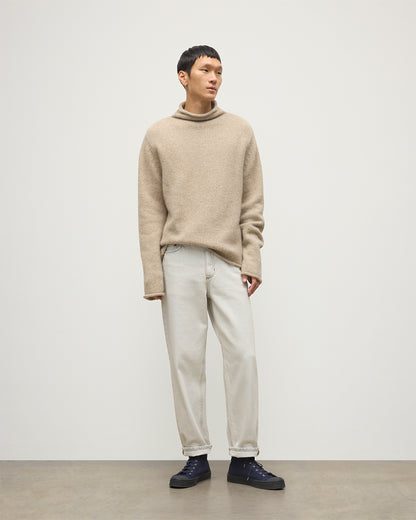 MALE MODEL WEARING JOHNSTOS OF ELGIN KESTER FUNNEL NECK SWEATER NATURAL 100% CASHMERE WITH WHITE JEANS KBB01067HB4453