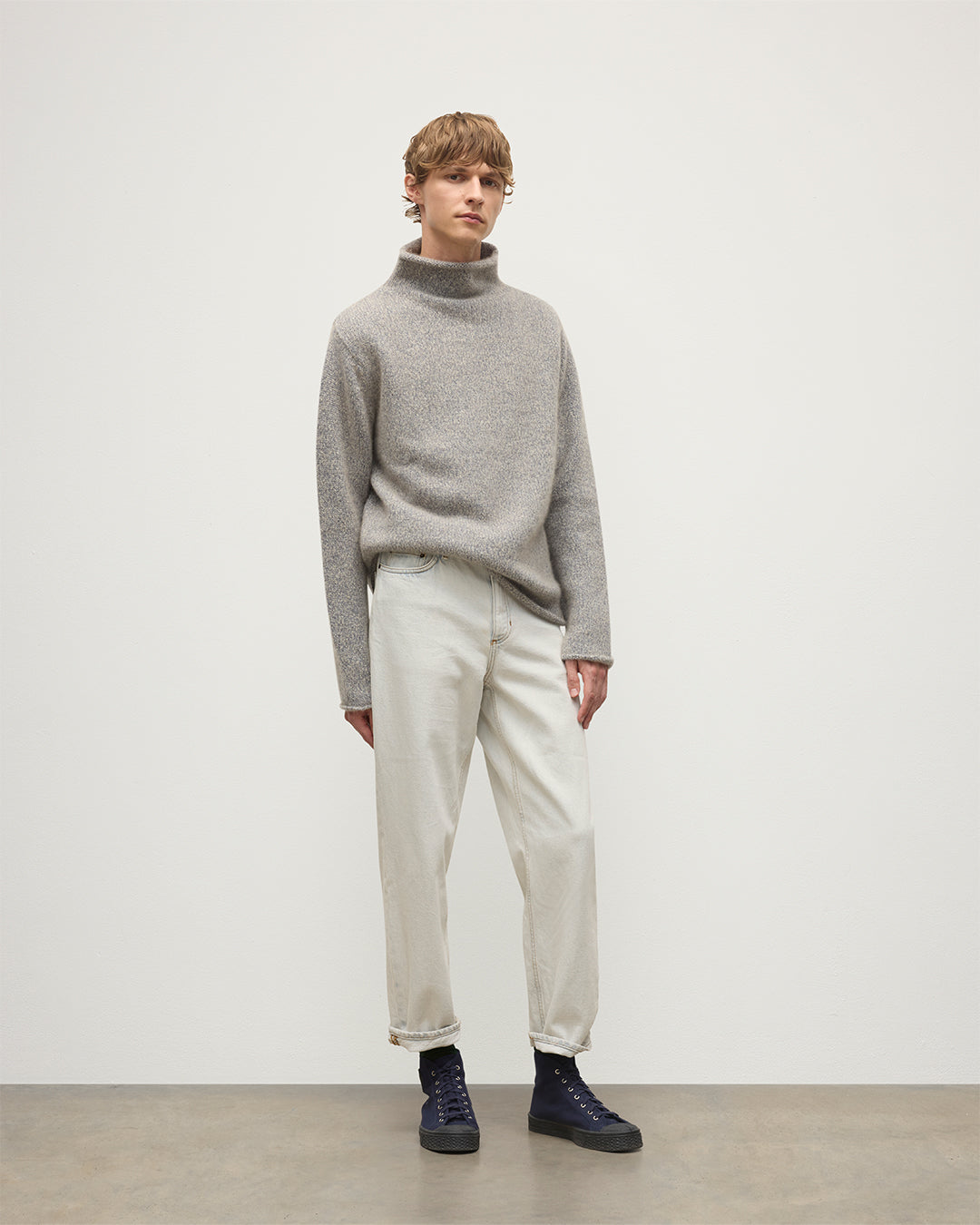 MALE MODEL WEARING JOHNSTONS OF ELGIN KESTER FUNNEL NECK SWEATER BLUE 100% CASHMERE WITH WHITE JEANS KBB01067HB4453