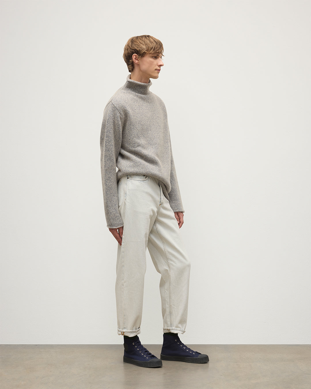MALE MODEL WEARING JOHNSTONS OF ELGIN KESTER FUNNEL NECK SWEATER BLUE 100% CASHMERE WITH WHITE JEANS KBB01067HB4453