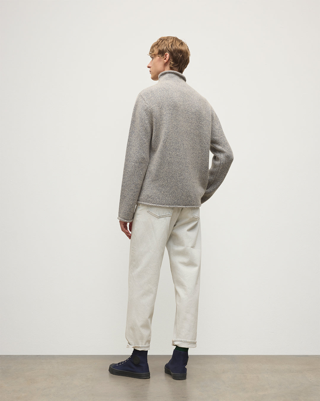 MALE MODEL WEARING JOHNSTONS OF ELGIN KESTER FUNNEL NECK SWEATER BLUE 100% CASHMERE WITH WHITE JEANS KBB01067HB4453