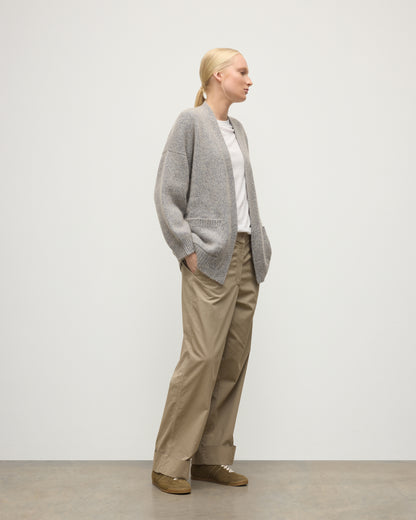 MODEL WEARS JOHNSTONS OF ELGIN WOMENS BAY SLOUCH CARDIGAN BLUE 78% CASHMERE 22% COTTON OVER A WHITE T-SHIRT WITH BROWN TROUSERS KBB01069HD4499