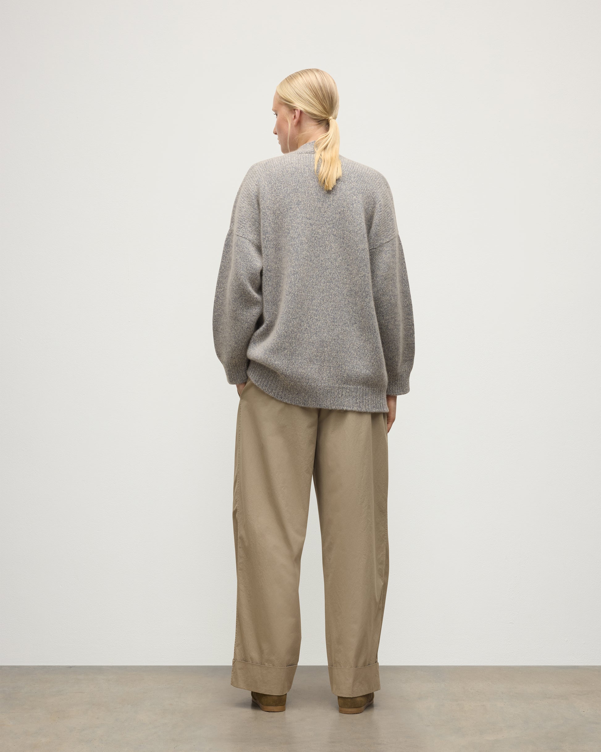 MODEL WEARS JOHNSTONS OF ELGIN WOMENS BAY SLOUCH CARDIGAN BLUE 78% CASHMERE 22% COTTON OVER A WHITE T-SHIRT WITH BROWN TROUSERS KBB01069HD4499