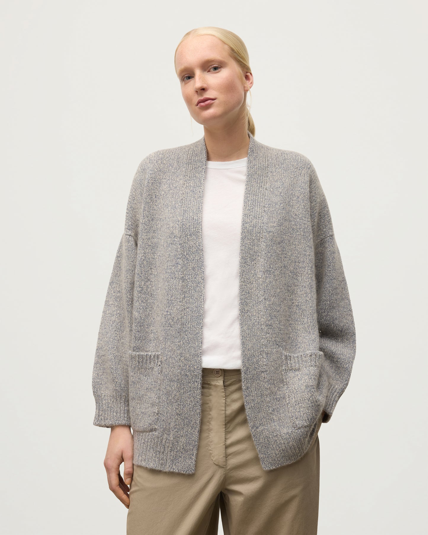 MODEL WEARS JOHNSTONS OF ELGIN WOMENS BAY SLOUCH CARDIGAN BLUE 78% CASHMERE 22% COTTON OVER A WHITE T-SHIRT KBB01069HD4499