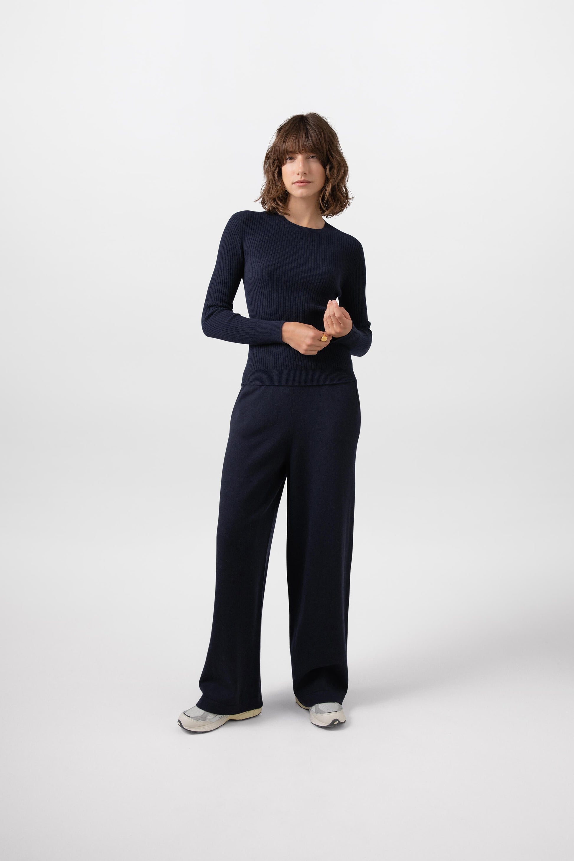 Johnstons of Elgin Knitted Cashmere Women's High Rise Wide Leg Trousers in Dark Navy worn with a matching Cashmere Sweater on a grey background KBP00926SD7286