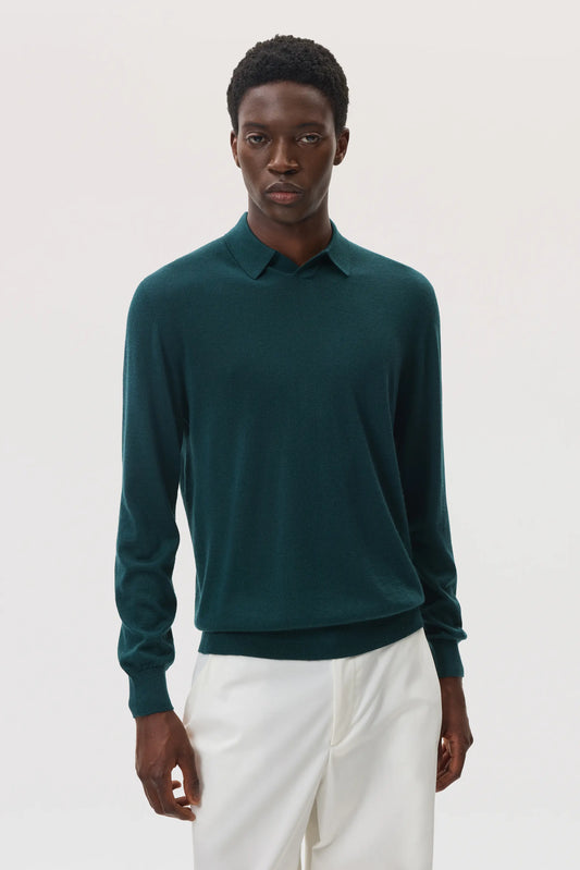 Model wears Johnstons of Elgin SS25 Men's Knitwear Emerald Superfine Cashmere Silk Polo Shirt with white trousers KBI00964SC7242