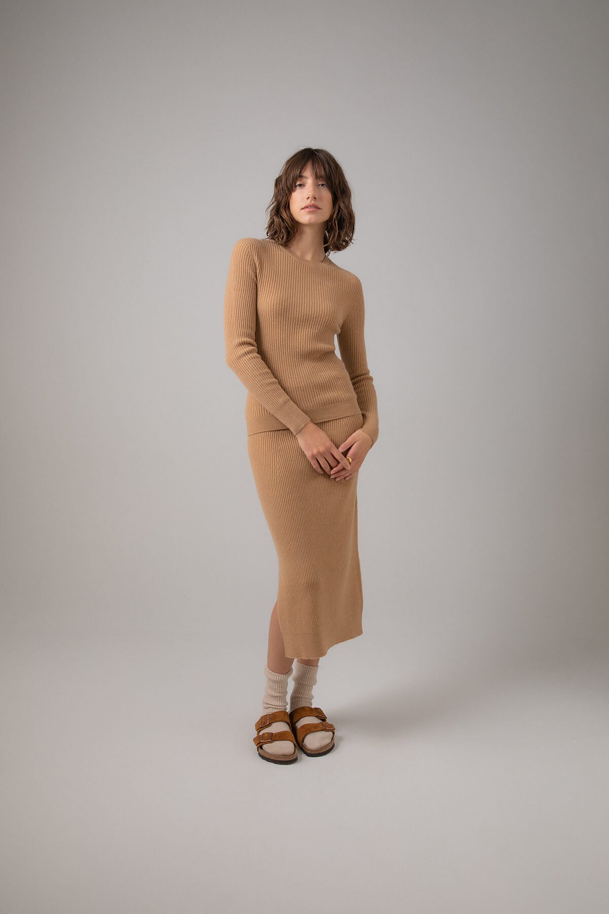 Johnstons of Elgin Ribbed Tube Cashmere Skirt in Camel worn with matching Slim Fit Cashmere Sweater on a grey background KBP00923HB4315