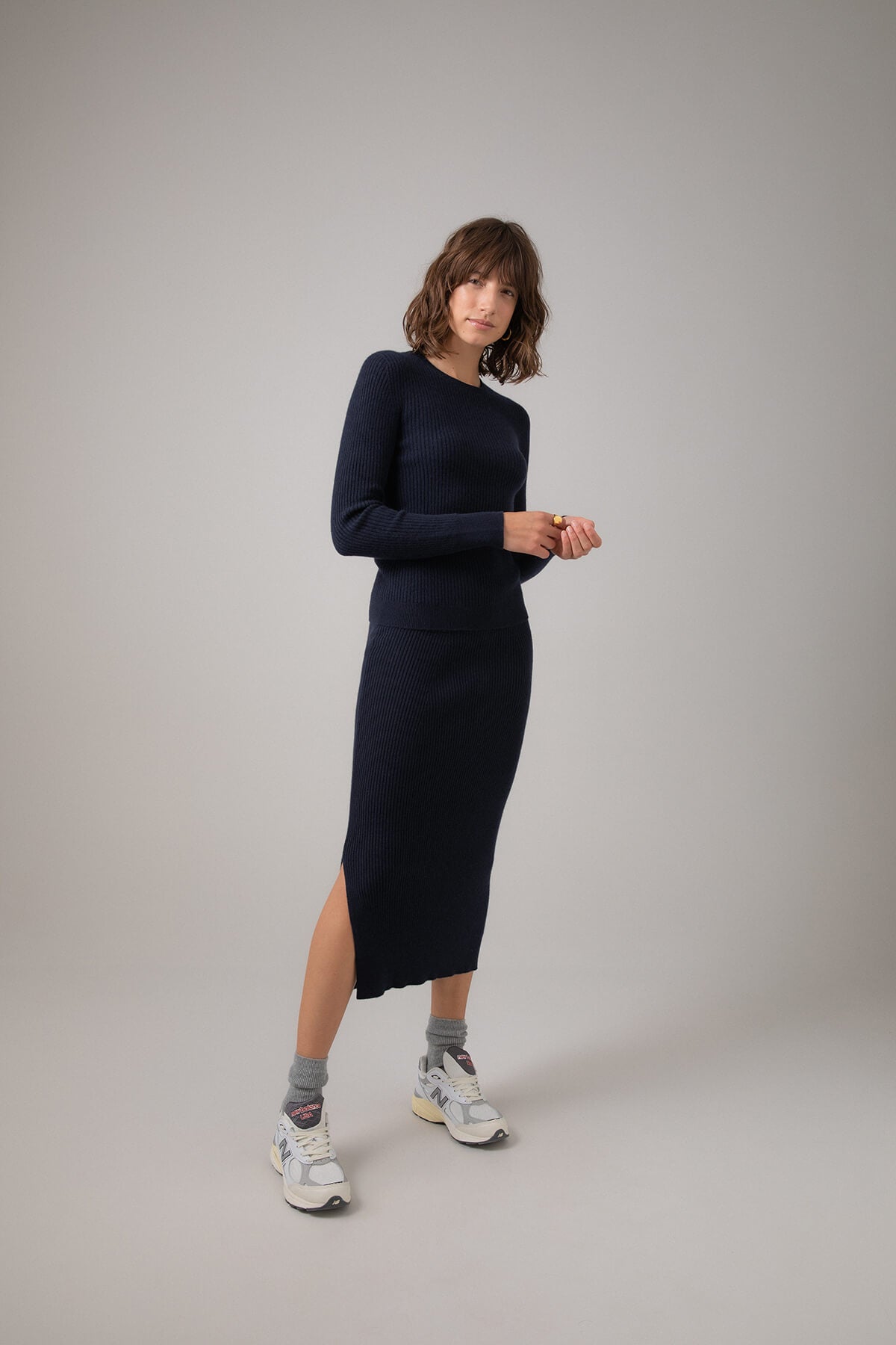 Johnstons of Elgin Ribbed Tube Cashmere Skirt in Dark Navy worn with matching Slim Fit Cashmere Sweater on a grey background KBP00923SD7286