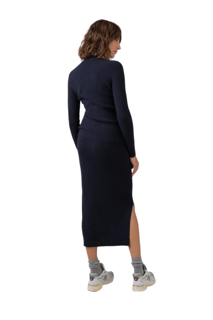 Back of Johnstons of Elgin Ribbed Tube Cashmere Skirt in Dark Navy worn with matching Slim Fit Cashmere Sweater on a grey background KBP00923SD7286