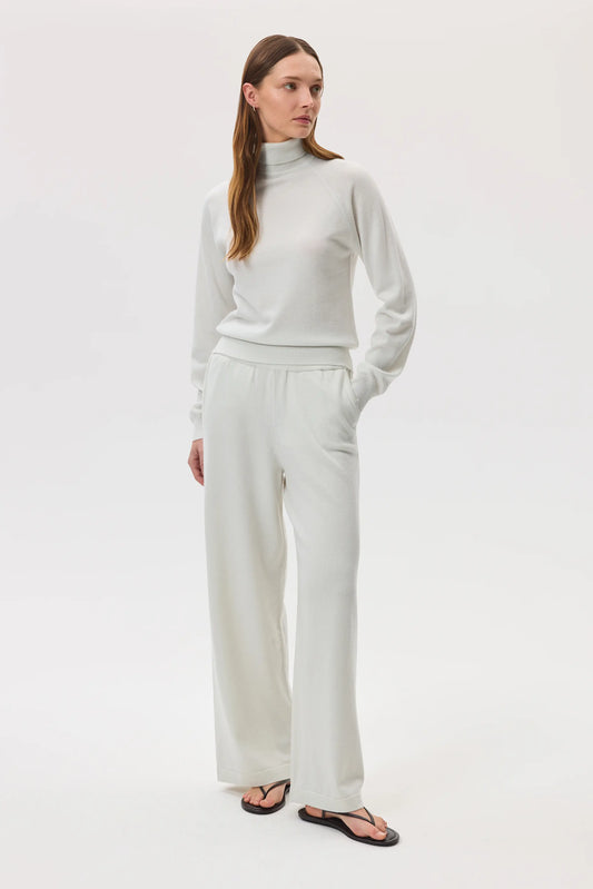 Johnstons of Elgin SS25 Women's Knitwear White High Rise Cashmere Culottes worn with a white cashmere roll neck sweater and black sandals KBP00926HA0346