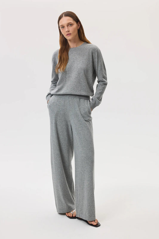 Model wearing Johnstons of Elgin SS25 Women's Knitwear Light Grey High Rise Cashmere Culottes with light grey cashmere crew neck sweater with black sandals KBP00926HA0200