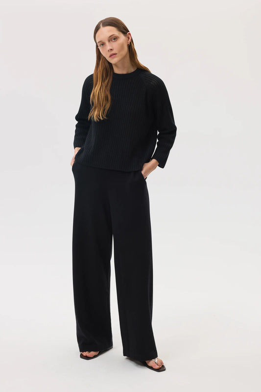 Model wearing Johnstons of Elgin SS25 Women's Knitwear Black High Rise Cashmere Culottes with black cashmere round neck sweater KBP00926SA7099