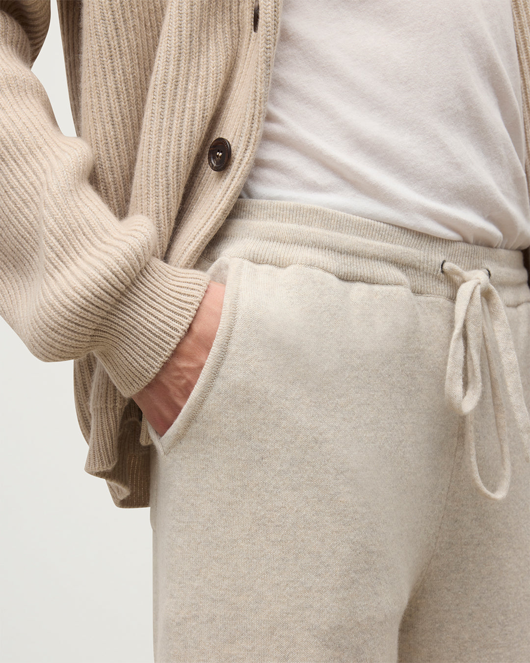 MODEL WEARING JOHNSTONS OF ELGIN MENS KIRK SWEATPANTS NATURAL 97% CASHMERE 3% POLYESTER WITH A WHITE T-SHIRT AND PIONEER CASHMERE CARDIGNA IN NATURAL KBP00948HA0402