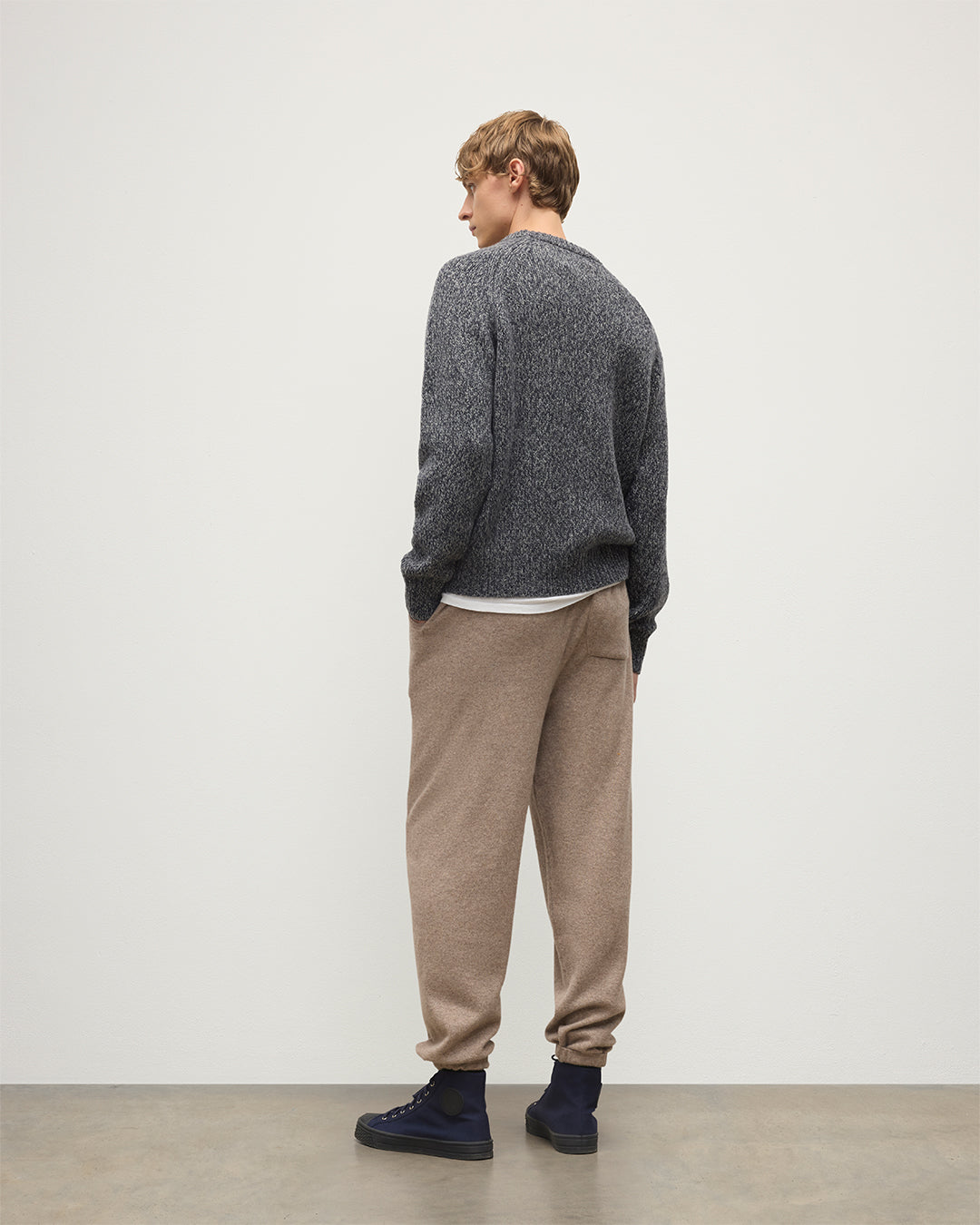 MODEL WEARS JOHNSTONS OF ELGIN MENS KIRK SWEATPANTS LIGHT BROWN 97% CASHMERE 3% POLYESTER WITH A  WHITE T-SHIRT AND NAVY FYFE CASHMERE SWEATER KBP00948HB4334