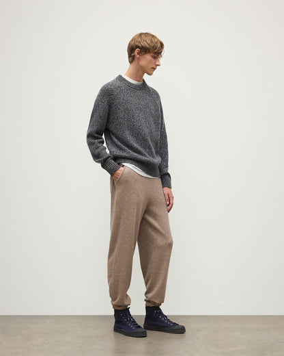 MODEL WEARS JOHNSTONS OF ELGIN MENS KIRK SWEATPANTS LIGHT BROWN 97% CASHMERE 3% POLYESTER WITH A  WHITE T-SHIRT AND NAVY FYFE CASHMERE SWEATER KBP00948HB4334