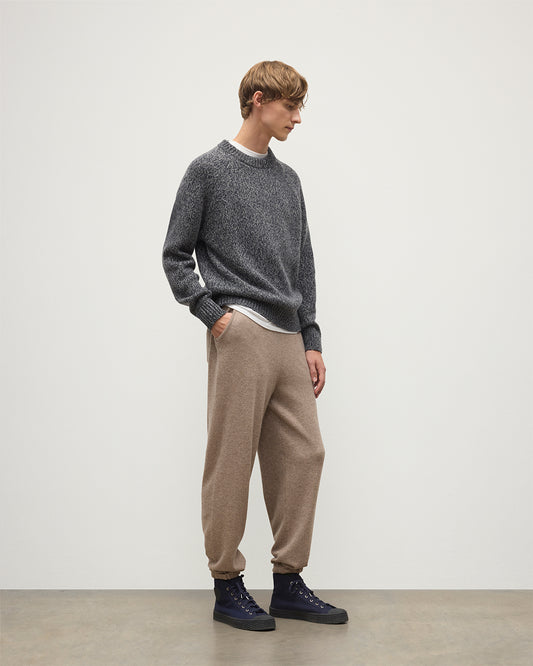 MODEL WEARS JOHNSTONS OF ELGIN MENS KIRK SWEATPANTS LIGHT BROWN 97% CASHMERE 3% POLYESTER WITH A  WHITE T-SHIRT AND NAVY FYFE CASHMERE SWEATER KBP00948HB4334