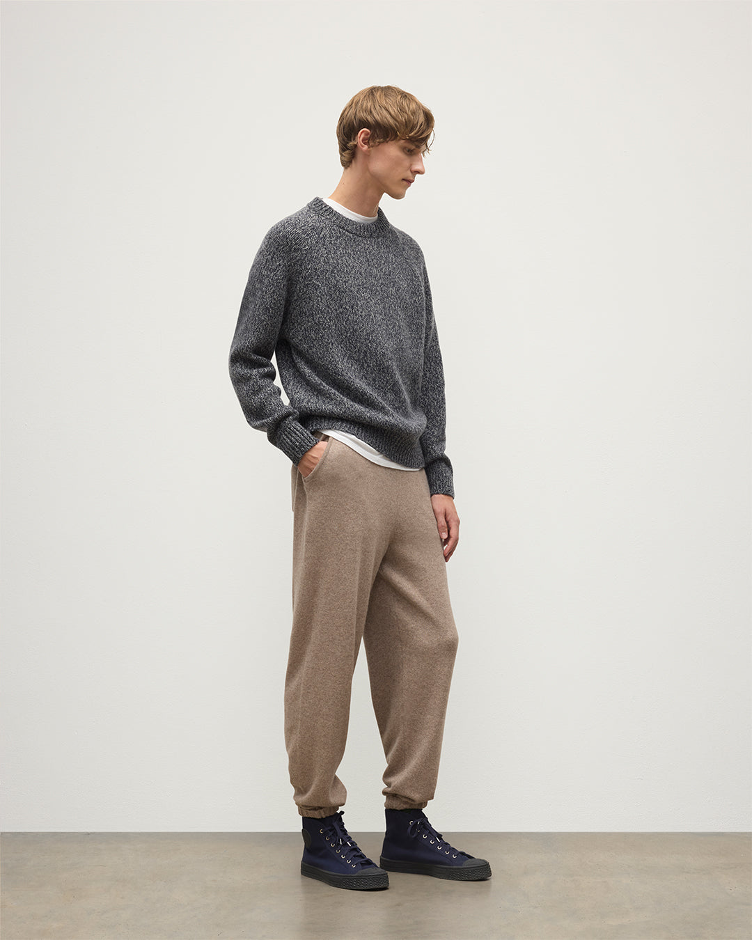 MODEL WEARS JOHNSTONS OF ELGIN MENS KIRK SWEATPANTS LIGHT BROWN 97% CASHMERE 3% POLYESTER WITH A  WHITE T-SHIRT AND NAVY FYFE CASHMERE SWEATER KBP00948HB4334