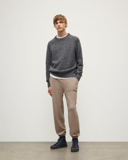 MODEL WEARS JOHNSTONS OF ELGIN MENS KIRK SWEATPANTS LIGHT BROWN 97% CASHMERE 3% POLYESTER WITH A  WHITE T-SHIRT AND NAVY FYFE CASHMERE SWEATER KBP00948HB4334