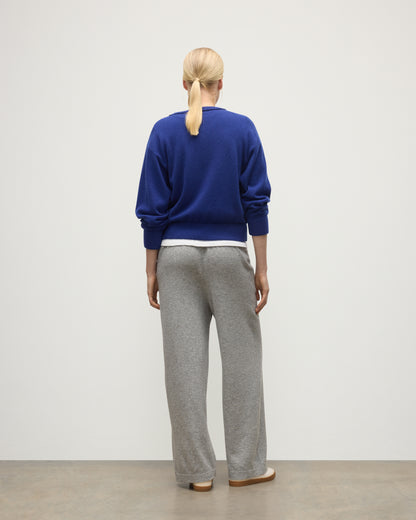 MODEL WEARS JOHNSTONS OF ELGIN WOMENS COLL PANTS LIGHT GREY WITH BLUE CASHMERE SWEATER OVER A WHITE T-SHIRT KBP00996HA0308