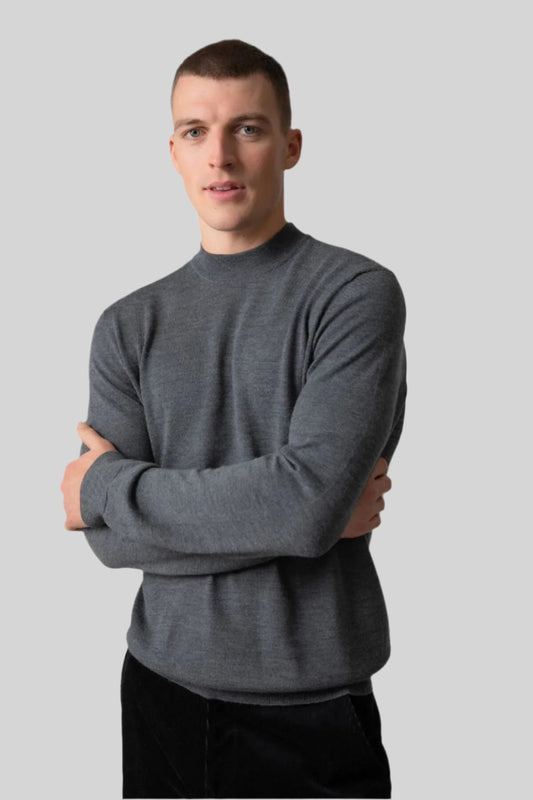 Johnstons of Elgin Men’s Merino Mock Turtleneck Jumper in Mid Grey on model wearing black trousers on grey background KDI00705HA7166