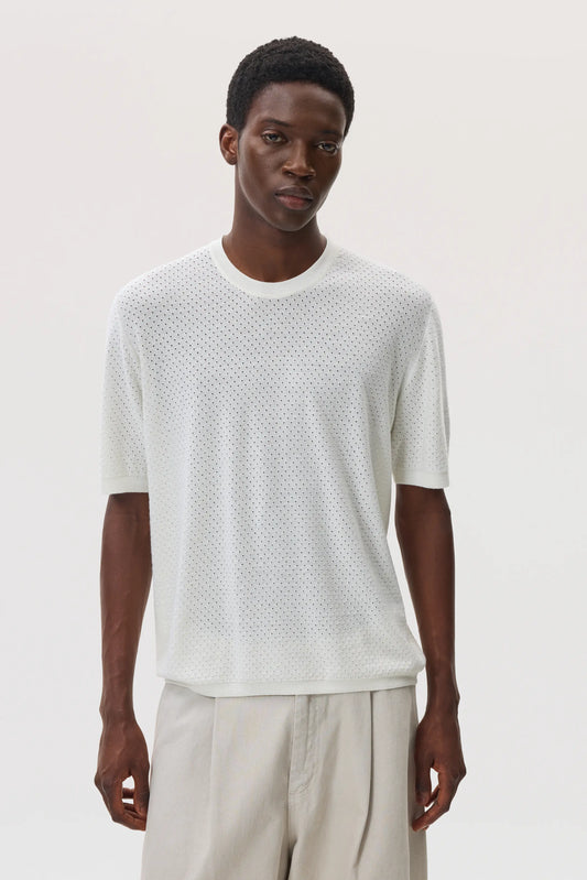 Model wearing Johnstons of Elgin SS25 Men's Knitwear White Superfine Merino Mesh T-Shirt with beige chinos  KDI00730SA0396