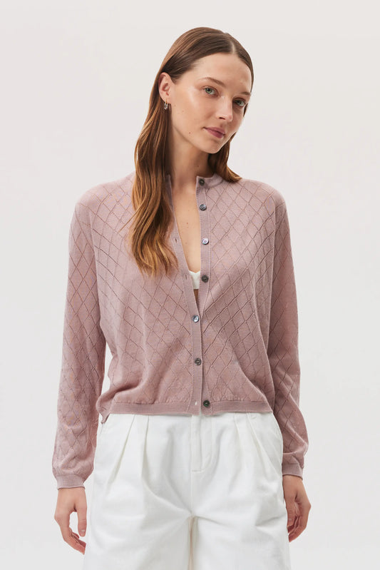 Model is wearing Johnstons of Elgin SS25 Women's Knitwear Dusty Rose Superfine Merino Pointelle Argyle Cardigan with white linen shorts  KDI00742SE5215