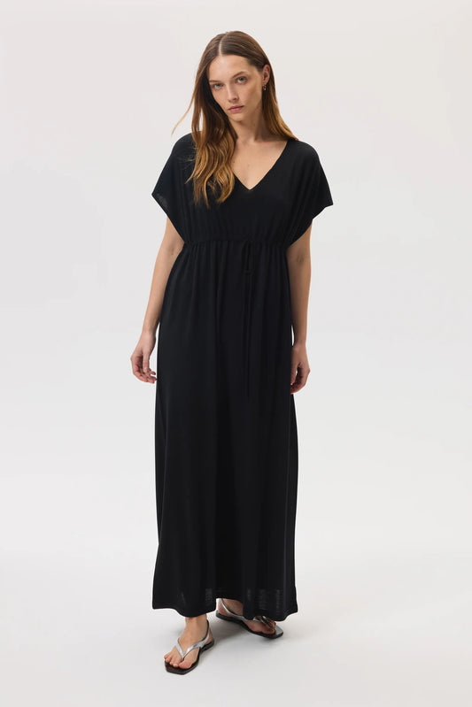 Model wears Johnstons of Elgin SS25 Women's Knitwear Black Superfine Merino Maxi Dress with silver sandals  KDI00744SA7131