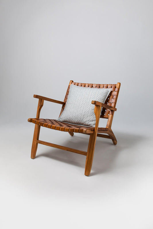 Johnstons of Elgin’s Silver & White Herringbone Jacquard Cushion on brown chair on a grey background PB000059RU6976ONE