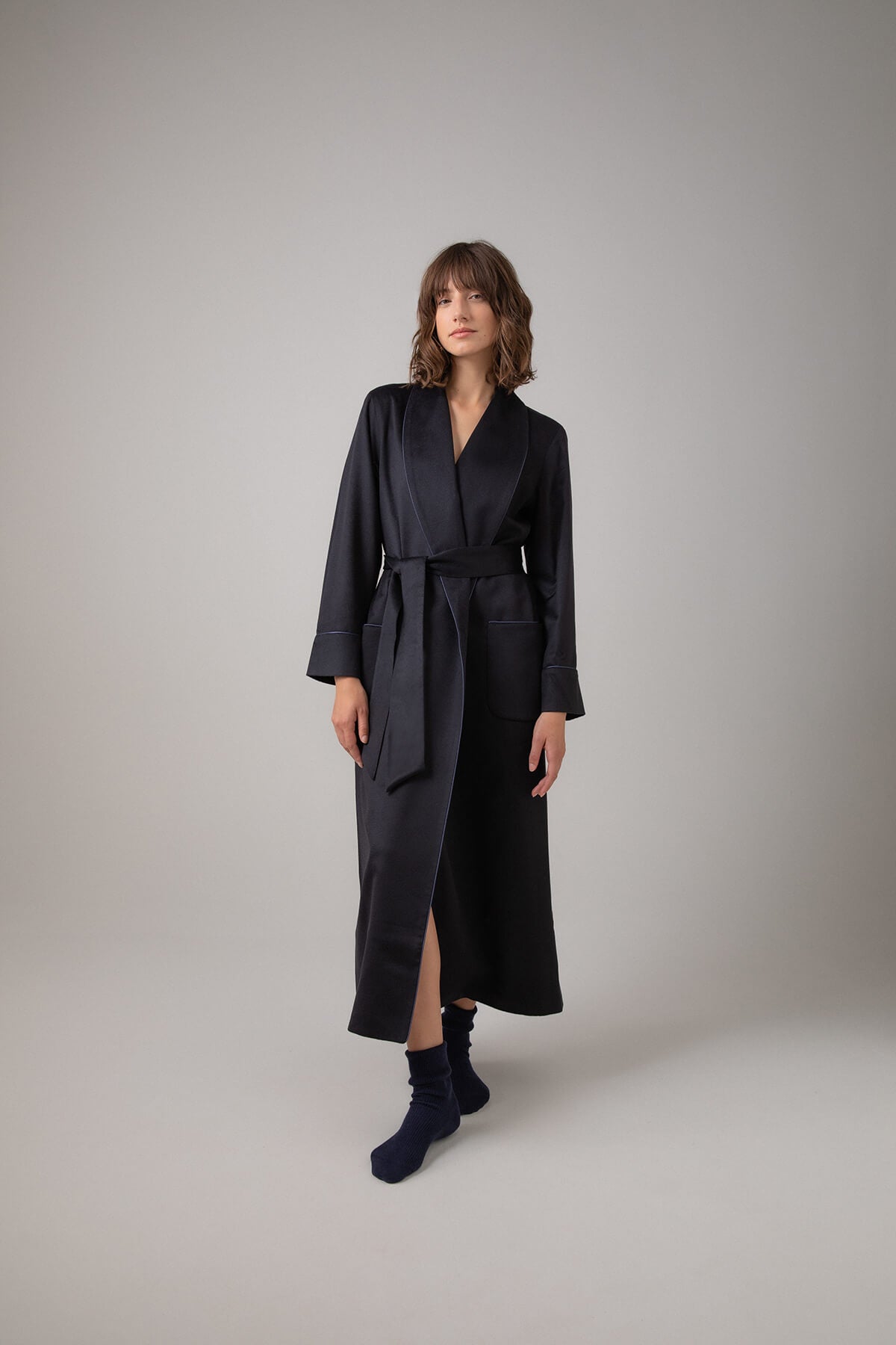 Johnstons of Elgin Women's Cashmere Dressing Gown with Silk Lining in Navy worn with Navy Cashmere Socks on a grey background TA000473RU65880