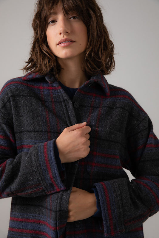 Johnstons of Elgin Women's Wool Blend Oversized Shirt in Charcoal Check worn with a Navy Cashmere Sweater on a grey background TB000630RU7387
