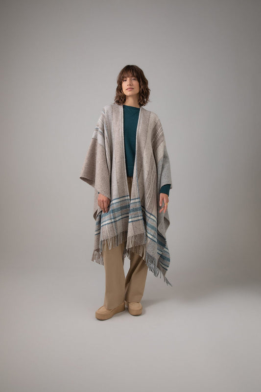 Johnstons of Elgin Cashmere Wool Blend Textured Donegal Cape Natural Multi worn over an Mallard Cashmere Sweater and Camel Trousers on a grey background TB000632RU7370ONE