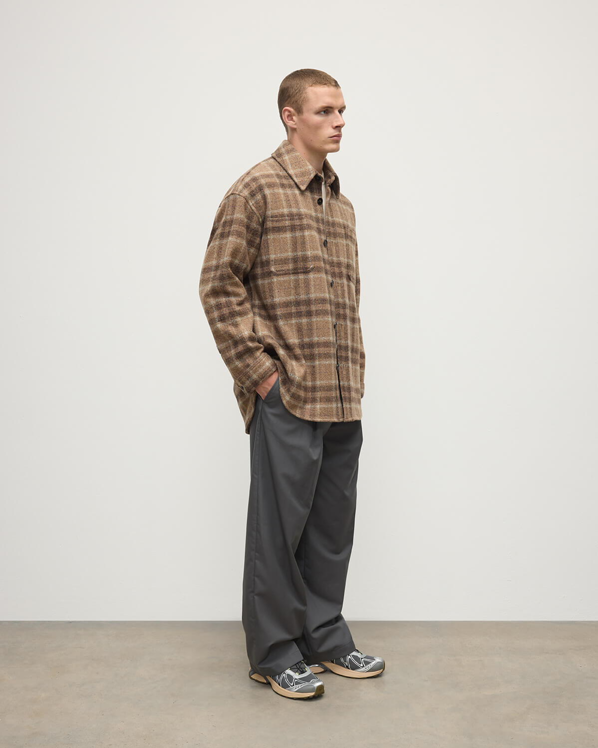 Model wears Johnstons of Elgin AW25 Men's Tailoring Vicuna Tweed Check Cashmere Wool Blend Brown Overshirt with grey trousers TB000755RU7683