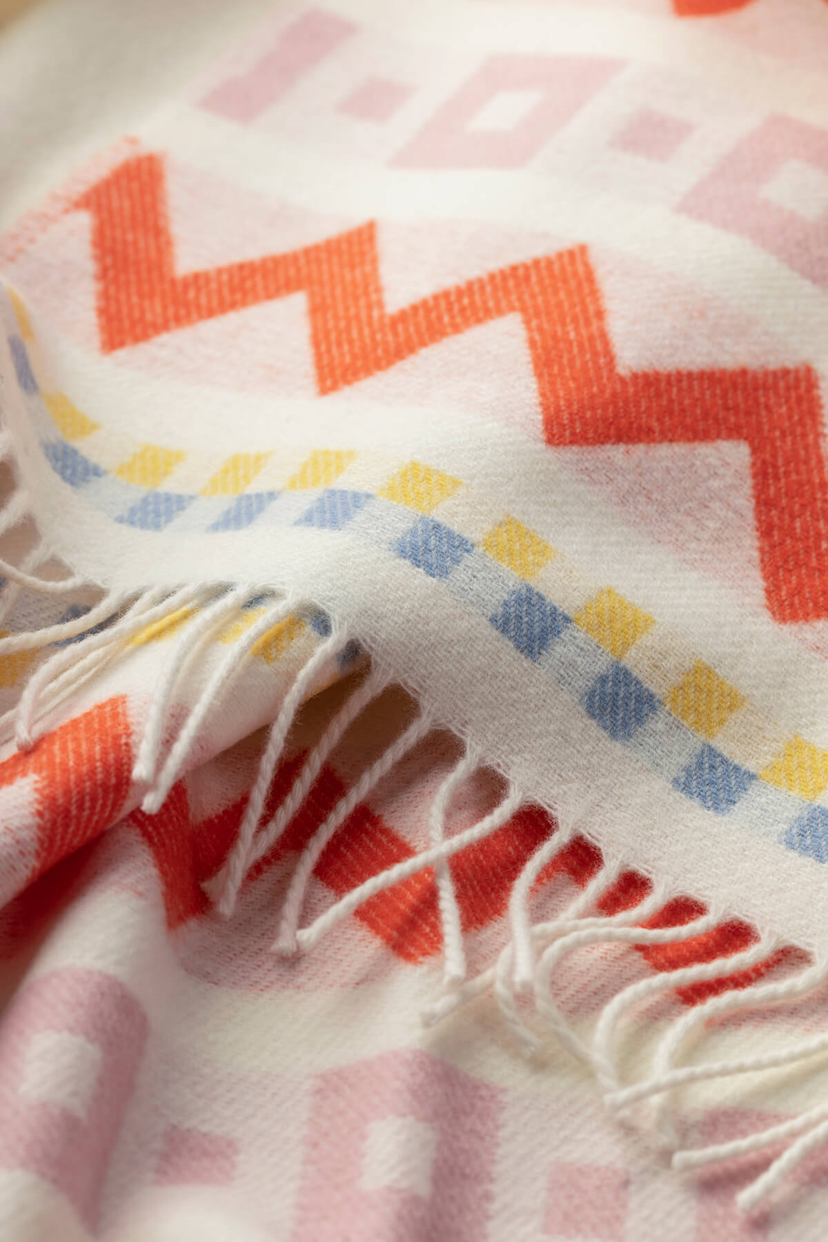 Detail image of Johnstons of Elgin Children's Zig Zag Blanket in shades of pink, orange, and cream WB002334RU7277ONE