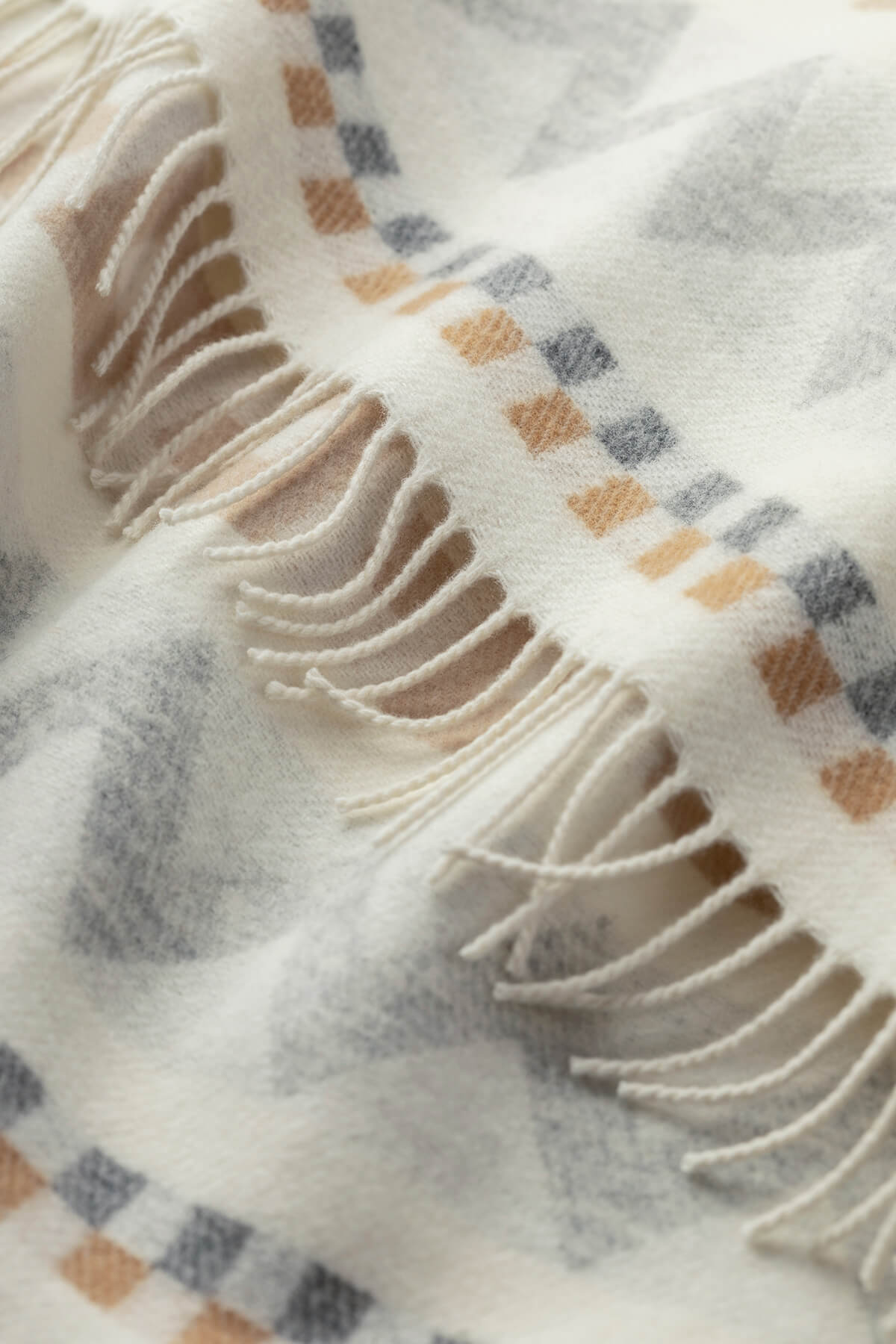 Detail Shot of Johnstons of Elgin Children's Zig Zag Blanket in shades of grey, camel, and cream on a white back ground. WB002334RU7278ONE