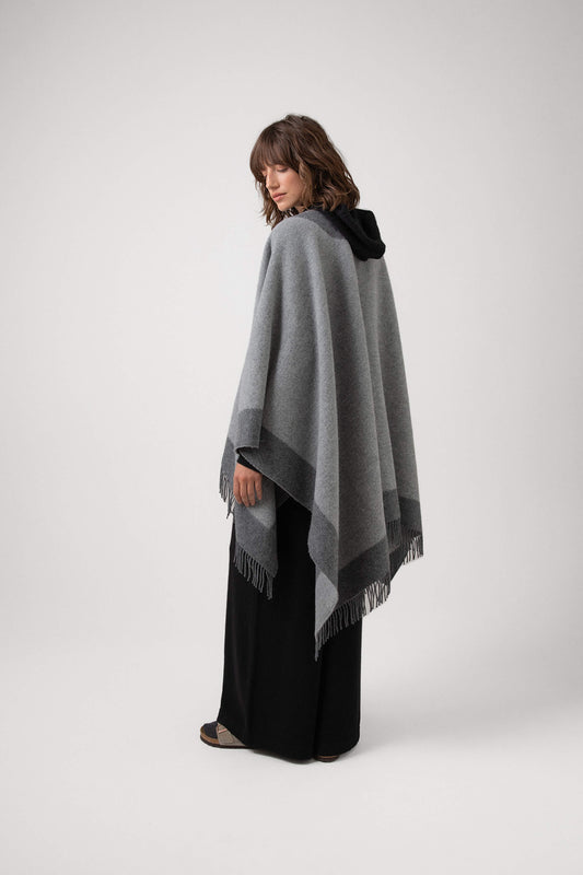 Back of Johnstons of Elgin Merino Wool Cape with Contrast Border in Grey worn over Navy hoodie & Joggers on a grey background TD000230RU7369ONE