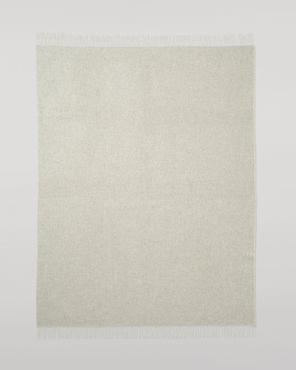 Johnstons of Elgin Interiors Collection Reversible Silver & White Cashmere Throw on a wooden chair WA000013RU5059ONE