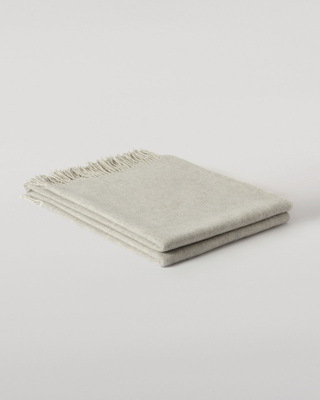 Johnstons of Elgin Interiors Collection Reversible Silver & White Cashmere Throw on a wooden chair WA000013RU5059ONE