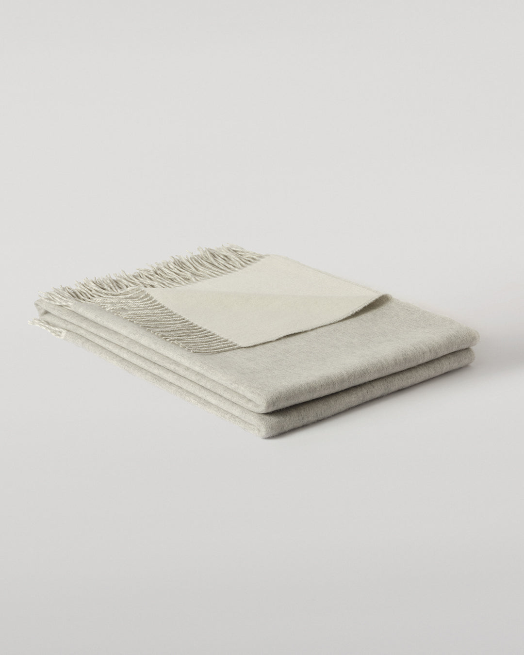 Johnstons of Elgin Interiors Collection Reversible Silver & White Cashmere Throw on a wooden chair WA000013RU5059ONE