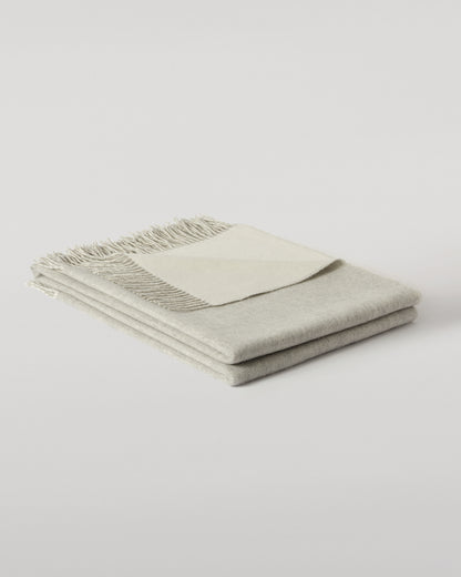 Johnstons of Elgin Interiors Collection Reversible Silver & White Cashmere Throw on a wooden chair WA000013RU5059ONE