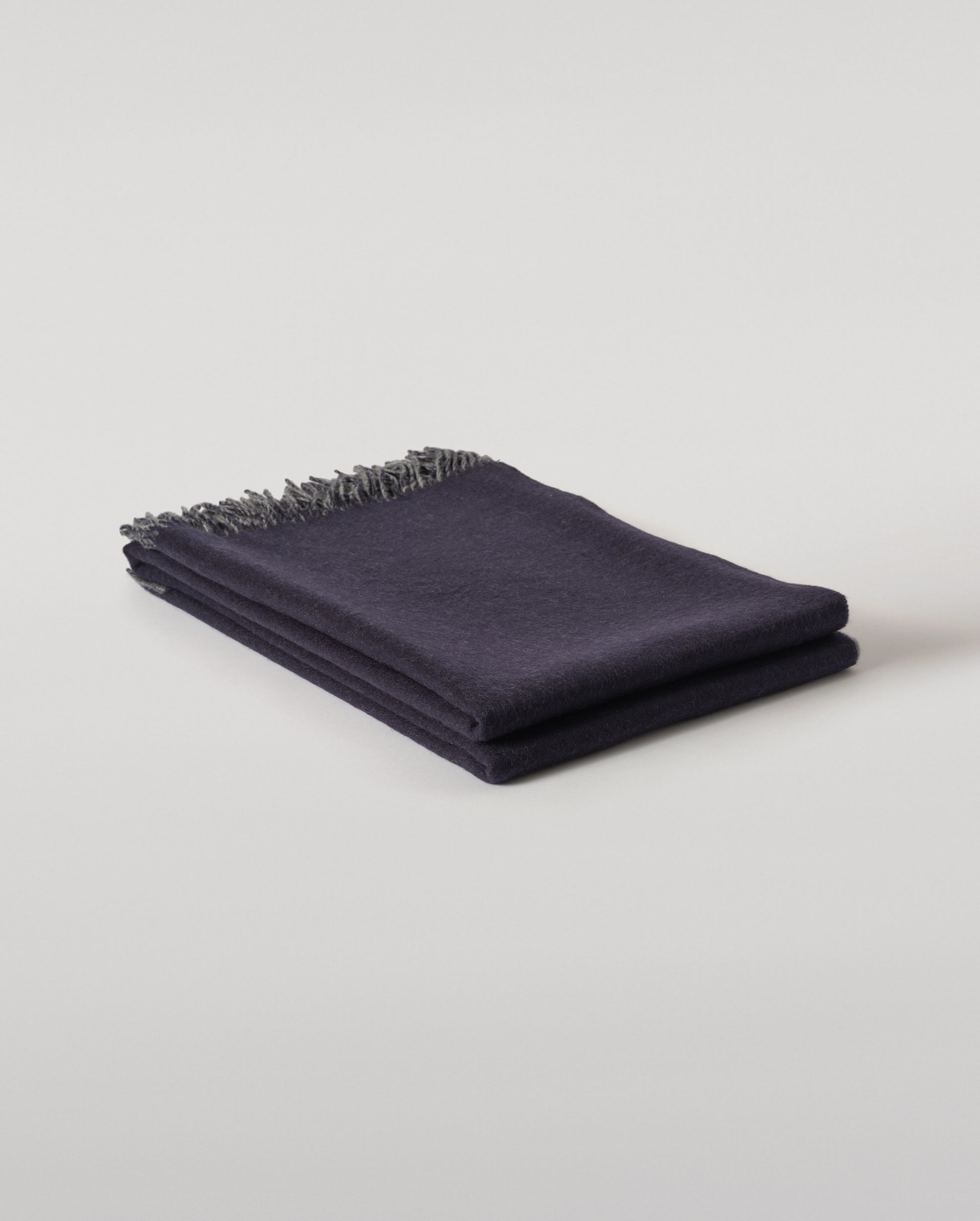 Johnstons of Elgin Interiors Collection  Reversible Navy & Light Grey Cashmere Throw on a wooden chair  WA000013RU6632N/A