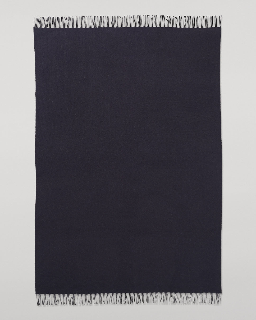 Johnstons of Elgin Interiors Collection  Reversible Navy & Light Grey Cashmere Throw on a wooden chair  WA000013RU6632N/A