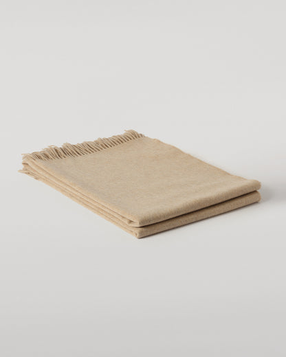Johnstons of Elgin Interiors Collection Oatmeal Cashmere Throw on a wooden chair WA000055HB0210ONE