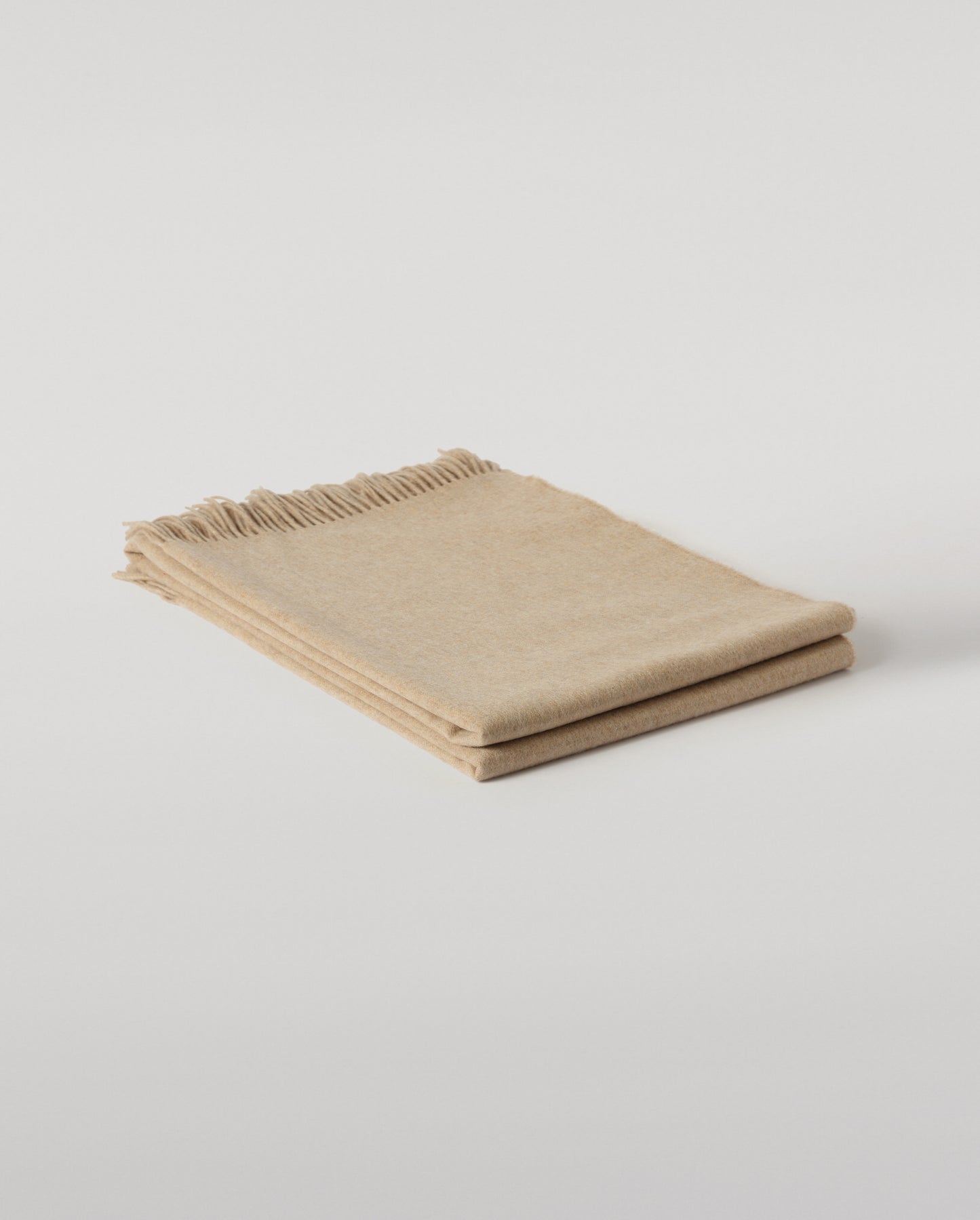 Johnstons of Elgin Interiors Collection Oatmeal Cashmere Throw on a wooden chair WA000055HB0210ONE