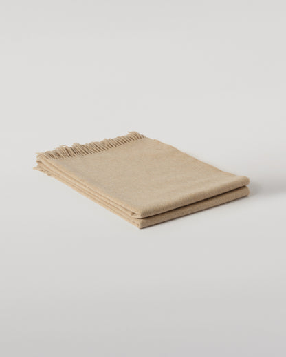 Johnstons of Elgin Interiors Collection Oatmeal Cashmere Throw on a wooden chair WA000055HB0210ONE