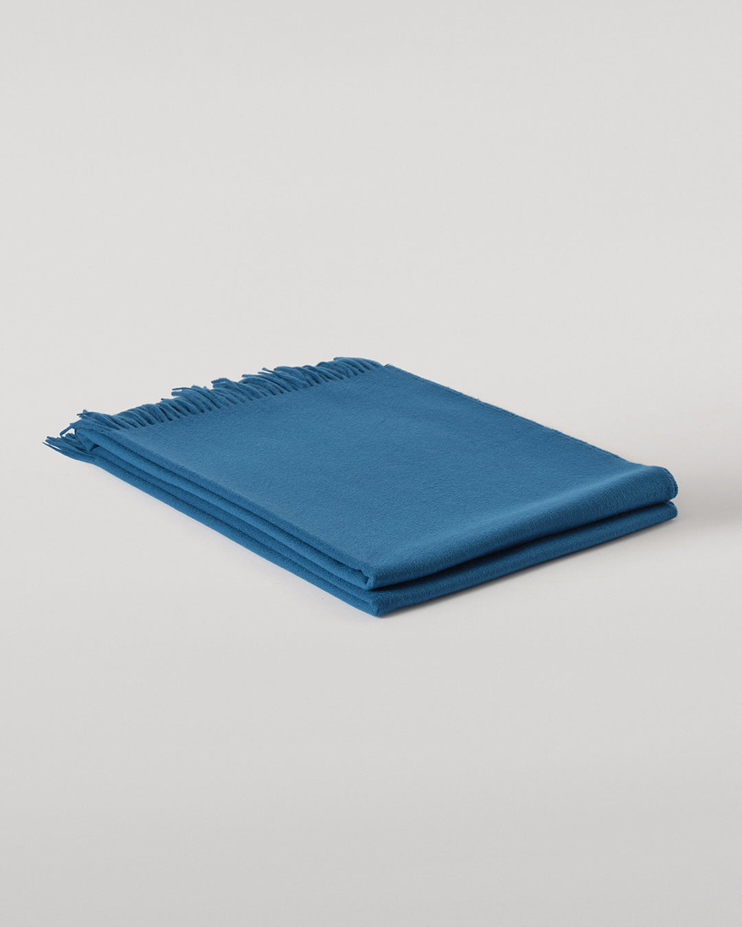 Johnstons of Elgin Plain Cashmere Throw in Petrol – luxury Scottish-woven cashmere throw in a rich petrol blue shade. WA000055SD5123ONE