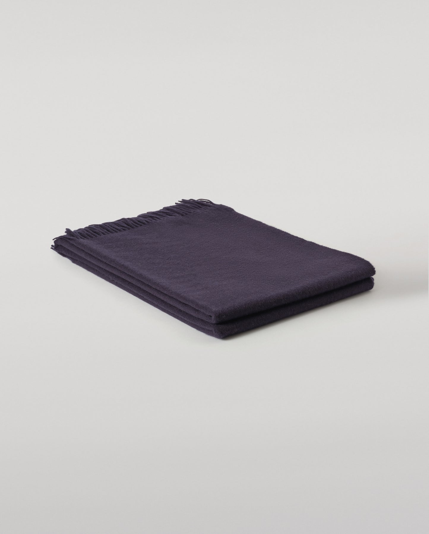 Johnstons of Elgin Interiors Collection  Dark Navy Cashmere Throw on a wooden chair   WA000055SD7330ONE