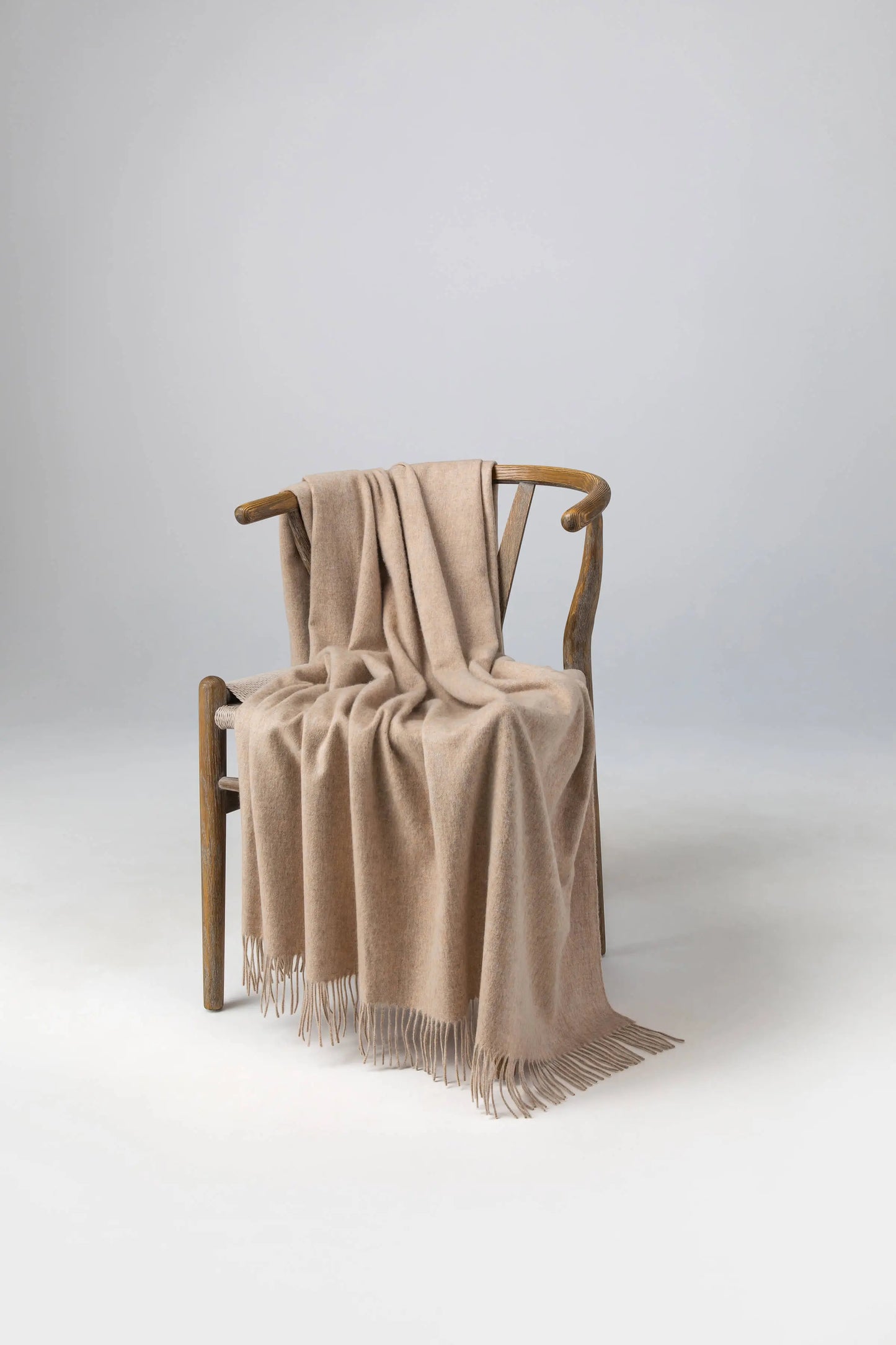 2025 Johnstons of Elgin Interiors Collection Oatmeal Cashmere Throw on a wooden chair WA000055HB0210ONE