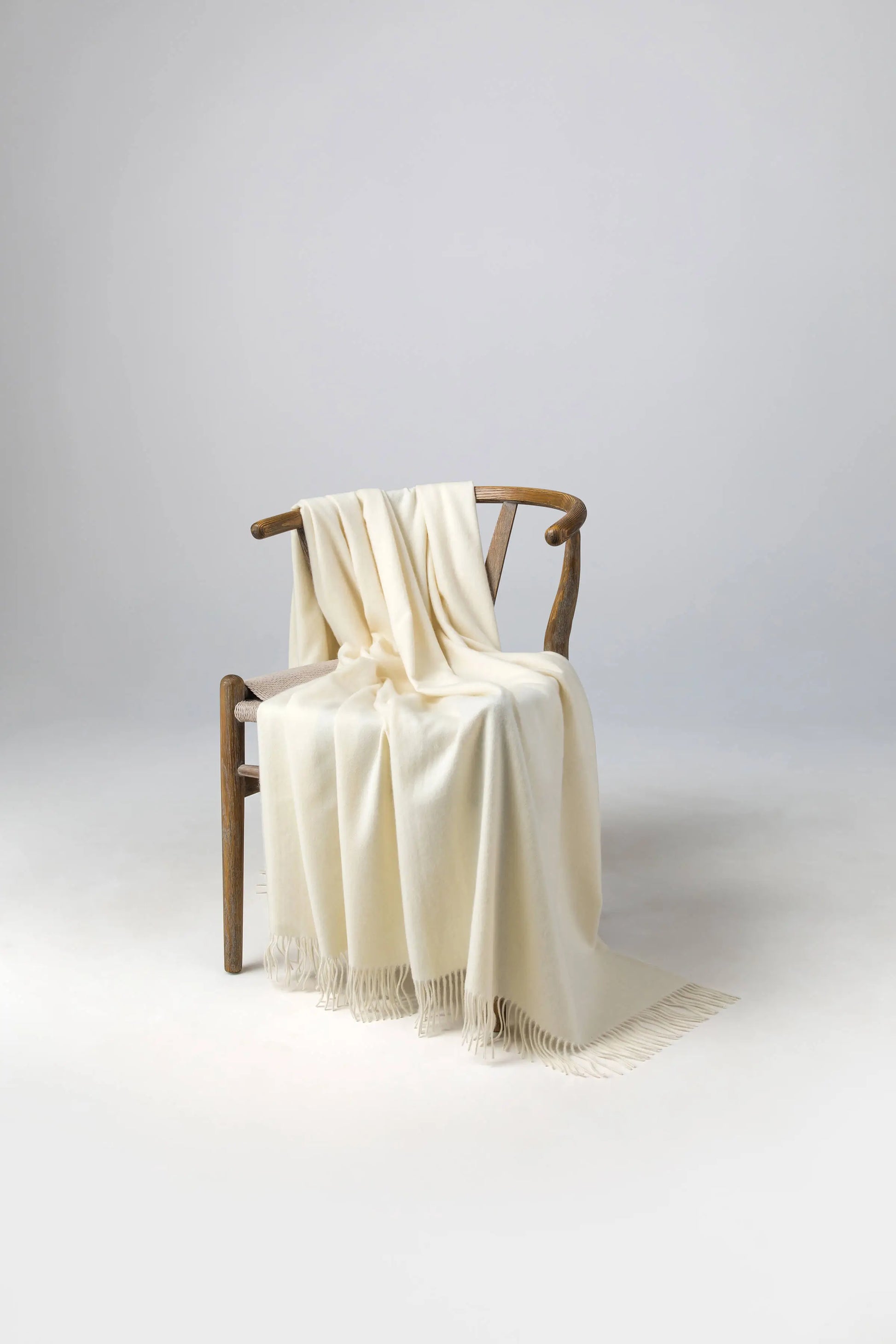 2025 Johnstons of Elgin Interiors Collection White Cashmere Throw on a wooden chair WA000055SA0000ONE