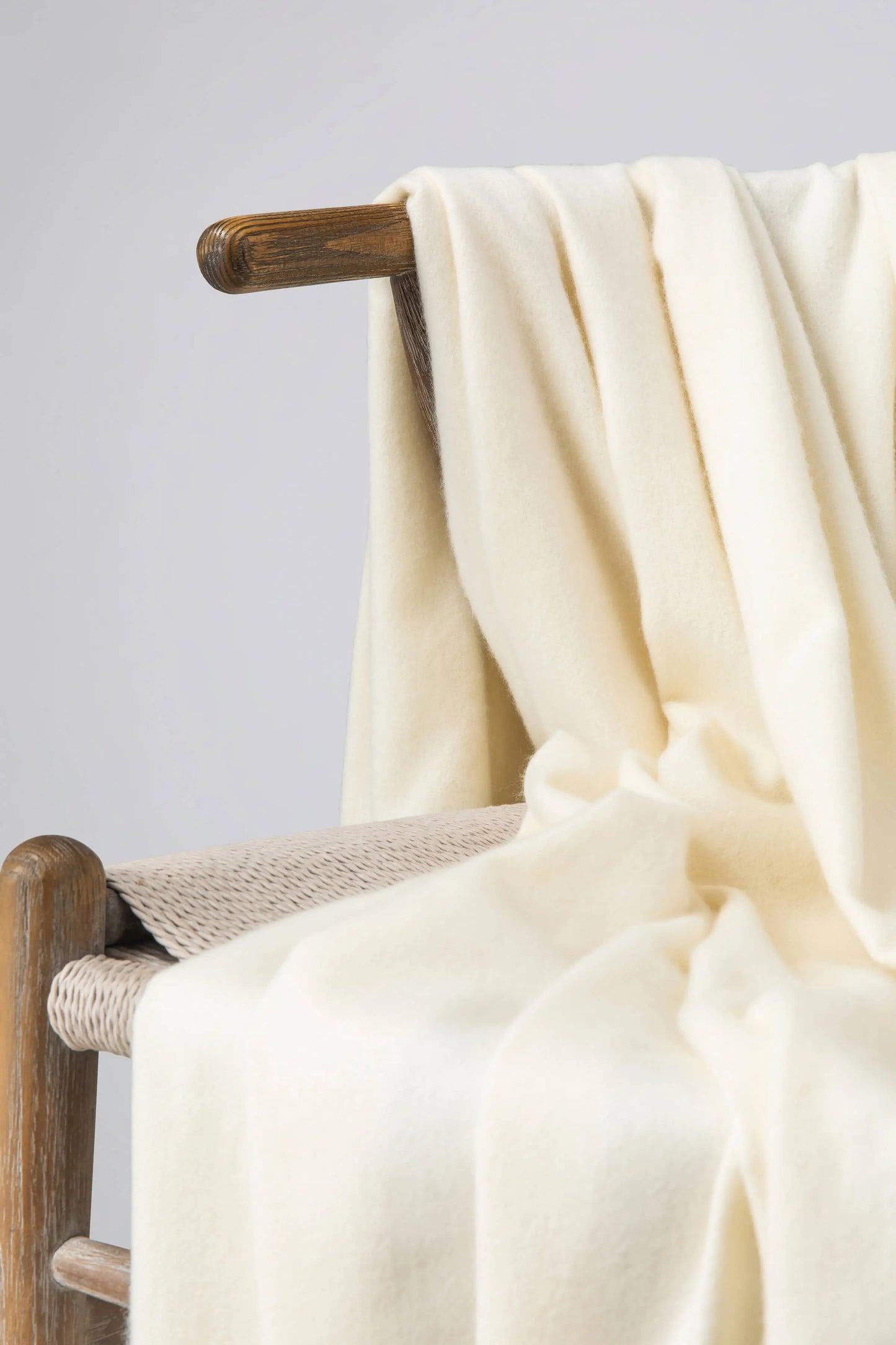 2025 Johnstons of Elgin Interiors Collection White Cashmere Throw on a wooden chair WA000055SA0000ONE