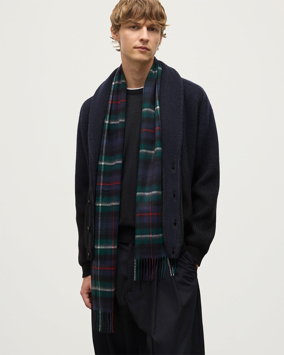 Model wears Johnstons of Elgin Woven Accessory MacKenzie Tartan Cashmere Scarf over Pioneer cashmere cardigan in black to navy  WA000016KU0309N/A